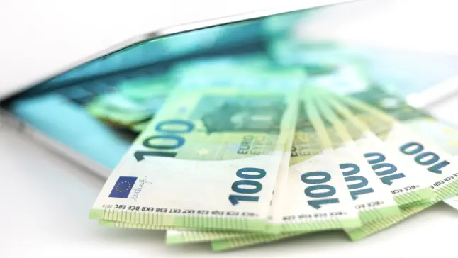 iStock 1356960127 kredit 100 Euro Noten auf Laptop klein Kredit