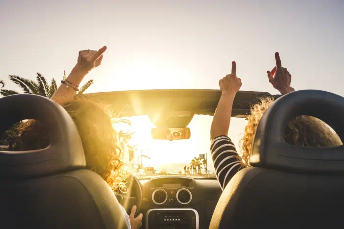 ein-paar-Freundinnen-haben-mit-dem-4baufi-Kreditrechner-Geld-eingespart-und-geniessen-ihren-Urlaub-im-neuen-Cabriolet