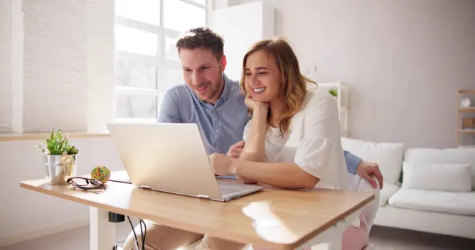 junges-Paar-berechnet-monatliche-rate-mit-dem-4baufi-baufinanzierungsrechner-am-Laptop